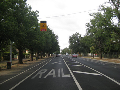 Tress obstructing view of level crossing